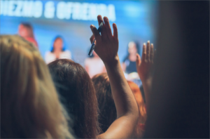 Woman in crowd raising her hand